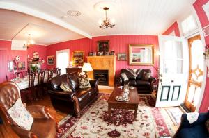a living room with leather furniture and a fireplace at Maison Hovington in Tadoussac +19 photos