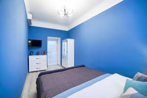 リヴィウにあるRomantic Apartment in the Сity Сenterの青いベッドルーム(ベッド1台、テレビ付)