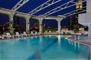una piscina con vista sullo skyline della città sullo sfondo di Furama City Centre a Singapore
