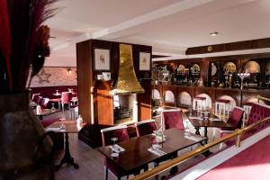 un restaurante con mesas y sillas y un bar en Leys Hotel en Aberdeen