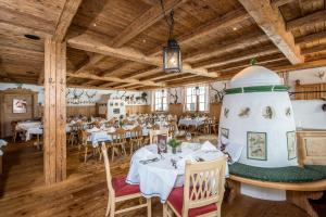 a dining room with tables and a large room with wooden ceilings at Hotel Leonhard in Leogang