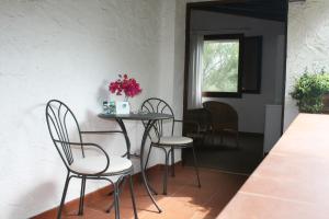 a dining room with chairs and a table with flowers on it at Hotel Villa Mediterranea in Noto Marina