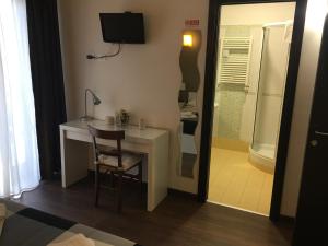 a room with a desk with a chair and a shower at Almi Rooms in Rome