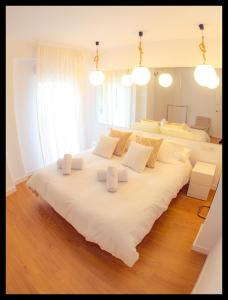 a large white bed with three pillows on it at La Peluquería in Córdoba