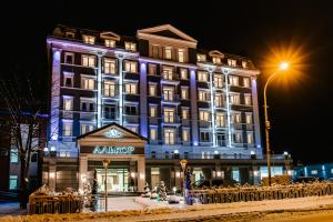 ein großes Gebäude mit beleuchteter Fassade in der Nacht in der Unterkunft Hotel Alkor in Truskawez