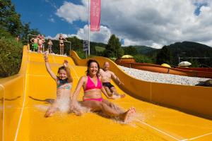 a group of children playing on a water slide at Haus Gumpold 2 in Wagrain