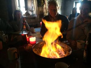 Ein Mann, der Essen in einer Pfanne mit Flammen kocht. in der Unterkunft Appart Sölkhof in Schöder