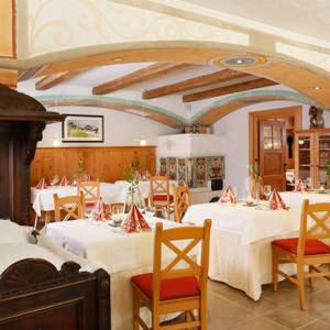 a dining room with white tables and chairs at Turmchalet in Braies