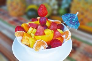 a bowl of fruit on a white plate at Hotel Puerto Gaviota in Tonsupa