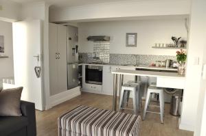 a kitchen with a counter and a table in a room at Lalapanzi in Fish Hoek