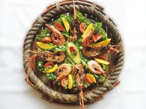 a basket of food with shrimp and vegetables in it at Hotel Puerto Gaviota in Tonsupa