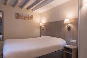 a hotel room with a large bed and two lamps at L'Ouest Hotel in Paris