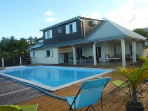 a house with a swimming pool in front of a house at La Pointe au Corail in Sainte-Rose