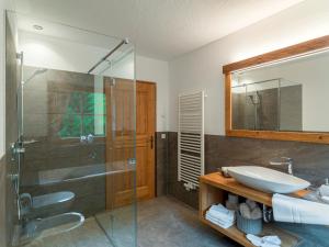a bathroom with a sink and a glass shower at Bruggerhof Prags in Braies