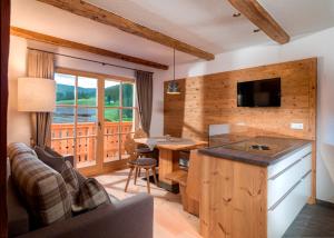 a living room with a couch and a kitchen with a table at Bruggerhof Prags in Braies