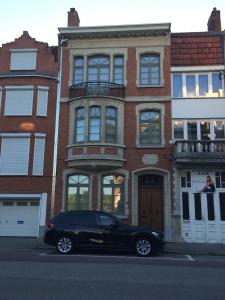 a black car parked in front of a building at Hasselt City Garden Duplex in Hasselt