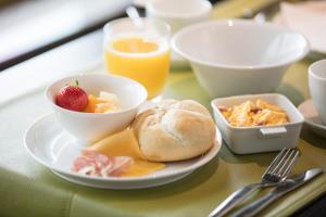 una mesa con un plato de comida y un bol de fruta en Hotel Essenza, en Puurs