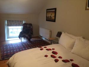 a room with a bed with roses on it at The Groom's Cottage in Navan