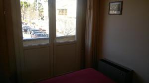 a room with a door and a window with cars in a parking lot at Hotel Centrale in Argenta