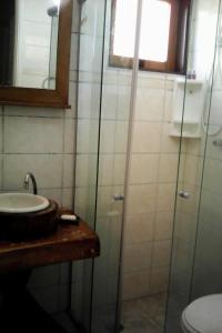 y baño con lavabo y ducha acristalada. en Condomínio Alto da Boa Vista, en Campos do Jordão