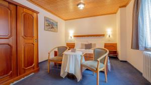 a room with a bed and a table and chairs at Alpenblick in Zermatt