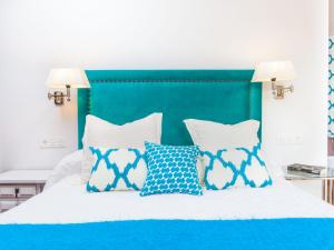 a bed with blue and white pillows on it at Villa Zurbarán by Interhome in Rincón de la Victoria