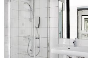 a white bathroom with a shower and a sink at Comfort Hotel Xpress Tromsø in Tromsø