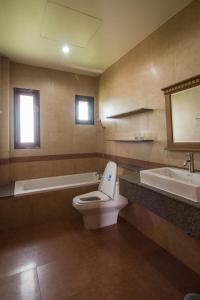 uma casa de banho com um WC, uma banheira e um lavatório. em Thaihome Resort em Ban Bang Muang