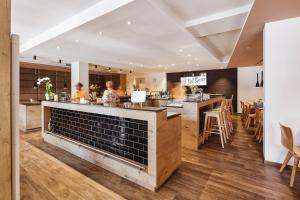 a restaurant with a bar with people preparing food at Hotel Goll Pforzheim-Niefern in Niefern-Öschelbronn