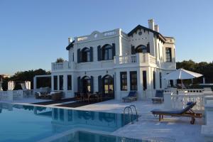 a large white house with a swimming pool at Mikamas Villas in Píryoi Thermís