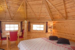 Cros-de-GéorandにあるLa Bergerie du Plateauの木造キャビン内のベッド1台が備わるベッドルーム1室を利用します。