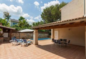 eine Terrasse mit Stühlen, einem Tisch und einem Pool in der Unterkunft Montferrutx in Colònia de Sant Pere