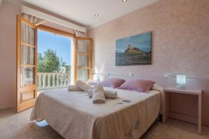 ein Schlafzimmer mit einem großen Bett und einem großen Fenster in der Unterkunft Montferrutx in Colònia de Sant Pere + 11 Fotos