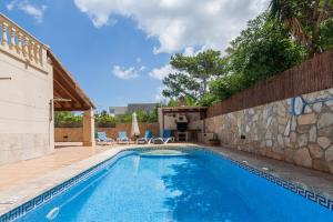 einen Pool im Hinterhof mit einer Steinmauer in der Unterkunft Montferrutx in Colònia de Sant Pere