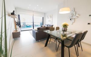 a living room with a glass table and a couch at Sunset Drive Benidorm by Mar Holidays in Benidorm