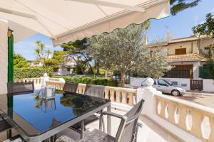 a balcony with a glass table and chairs at Verdera in Playa de Muro