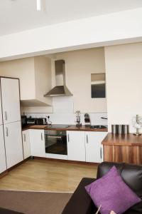 a kitchen with white cabinets and a purple pillow at Parks Nest 5 in Hull