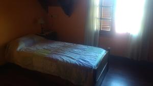 una camera con un letto in una stanza con una finestra di Chalet Bosque Peralta Ramos a Mar del Plata