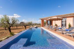 a swimming pool with chairs and a villa at Son Bordils in Inca