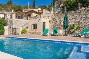 a villa with a swimming pool in front of a house at Sa Font in Puigpunyent