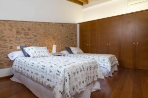 a bedroom with two beds with white comforters at Casa Puça in Sa Pobla
