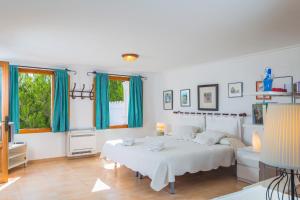 a white bedroom with a bed and a table at Franciscus in Playa de Muro