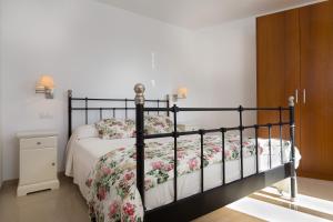 um quarto com uma cama com colcha floral em Casa Biali em Búger