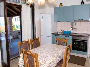 a kitchen with a table and a white refrigerator at Apartments Vukovic in Postira