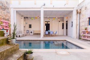 a pool in the middle of a building with blue chairs at La Penya in Sa Pobla