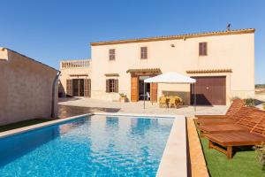 eine Villa mit einem Swimmingpool vor einem Haus in der Unterkunft Can Pont in Manacor