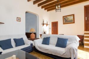 ein Wohnzimmer mit zwei weißen Sofas und blauen Kissen in der Unterkunft Can Pont in Manacor