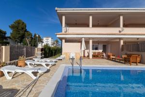 a villa with a swimming pool in front of a house at Jeronimo in Playa de Muro