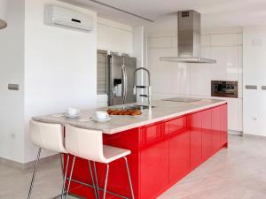 Monte PegoにあるHoliday Home Calatrava by Interhomeの赤いキャビネットと赤と白のカウンター付きのキッチン