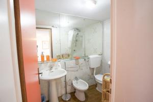 a bathroom with a sink and a toilet and a mirror at Villino Lacona in Capoliveri